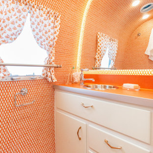 Inspiration för ett litet eklektiskt orange oranget badrum med dusch, med släta luckor, vita skåp, en toalettstol med hel cisternkåpa, orange kakel, orange väggar, målat trägolv, ett nedsänkt handfat, laminatbänkskiva och orange golv