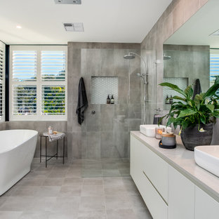 Design ideas for a contemporary bathroom in Sydney with flat-panel cabinets, white cabinets, a freestanding tub, gray tile, a vessel sink, grey floor, grey benchtops and a double vanity.