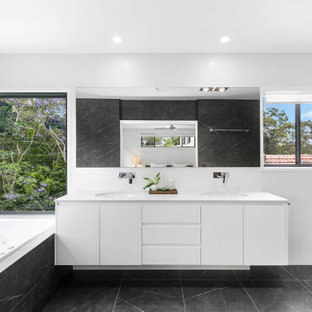 Design ideas for a mid-sized contemporary master bathroom in Brisbane with shaker cabinets, white cabinets, a hot tub, an alcove shower, a one-piece toilet, black and white tile, porcelain tile, black walls, porcelain floors, an undermount sink, engineered quartz benchtops, black floor, an open shower, white benchtops, a niche, a double vanity and a floating vanity.