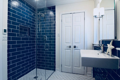 Mid-sized beach style master blue tile and porcelain tile porcelain tile and white floor walk-in shower photo in Toronto with a two-piece toilet, white walls, a pedestal sink, a hinged shower door and white countertops