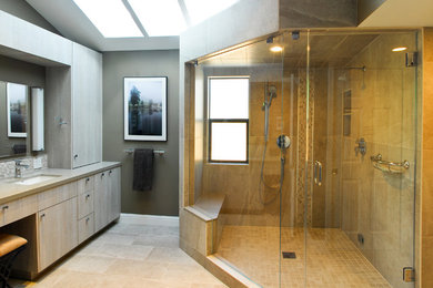 Double shower - mid-sized transitional master beige tile and ceramic tile ceramic tile and beige floor double shower idea in San Francisco with flat-panel cabinets, gray walls, an undermount sink, light wood cabinets, limestone countertops and a hinged shower door