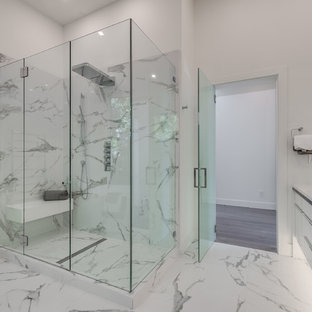 Modern master bathroom in Vancouver with glass-front cabinets, white cabinets, a freestanding tub, an open shower, white tile, stone tile, white walls, marble floors, a vessel sink, engineered quartz benchtops, white floor, a hinged shower door, white benchtops and a wall-mount toilet.