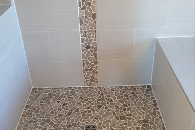 Imagen de cuarto de baño clásico renovado de tamaño medio con ducha empotrada, baldosas y/o azulejos beige, baldosas y/o azulejos marrones, losas de piedra, suelo de baldosas de porcelana, paredes grises y suelo gris