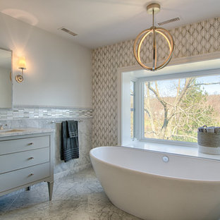Ispirazione per una stanza da bagno padronale tradizionale di medie dimensioni con consolle stile comò, ante grigie, vasca freestanding, piastrelle a mosaico, lavabo sottopiano, pareti grigie e pavimento in marmo
