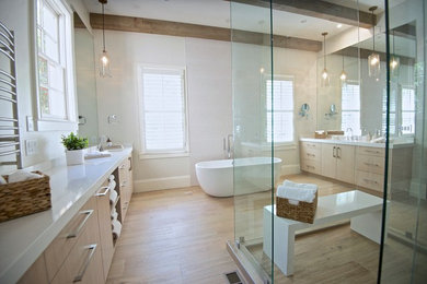 Inspiration for an expansive traditional ensuite bathroom in Atlanta with flat-panel cabinets, light wood cabinets, a freestanding bath, a walk-in shower, white tiles, ceramic flooring, a submerged sink, engineered stone worktops, brown floors and white worktops.