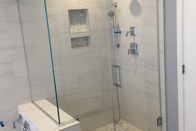 Aménagement d'une salle de bain avec une douche d'angle et une cabine de douche à porte battante.