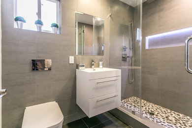 Example of a mid-sized trendy gray tile and porcelain tile porcelain tile sauna design in Los Angeles with white cabinets, a wall-mount toilet, gray walls and an integrated sink