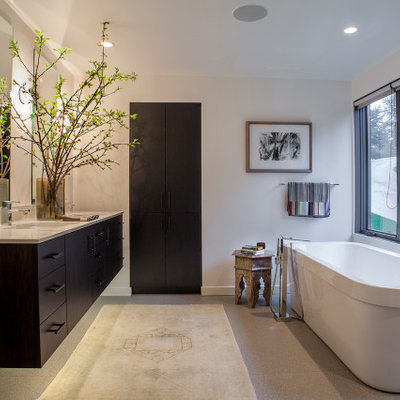 Freestanding bathtub - large contemporary master gray floor freestanding bathtub idea in Portland with flat-panel cabinets, dark wood cabinets, white walls, an undermount sink and beige countertops