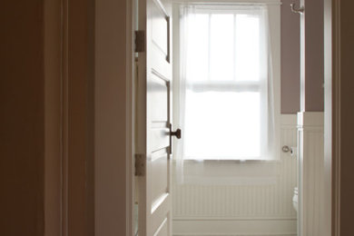 ポートランドにある低価格の中くらいなトラディショナルスタイルのおしゃれなバスルーム (浴槽なし) (アンダーカウンター洗面器、シェーカースタイル扉のキャビネット、白いキャビネット、クオーツストーンの洗面台、アルコーブ型シャワー、分離型トイレ、白いタイル、サブウェイタイル、セラミックタイルの床、茶色い壁) の写真