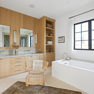 Bathroom - large transitional master white tile and travertine tile limestone floor, beige floor, double-sink and coffered ceiling bathroom idea in Los Angeles with recessed-panel cabinets, beige cabinets, a one-piece toilet, white walls, an undermount sink, limestone countertops, a hinged shower door, gray countertops and a built-in vanity