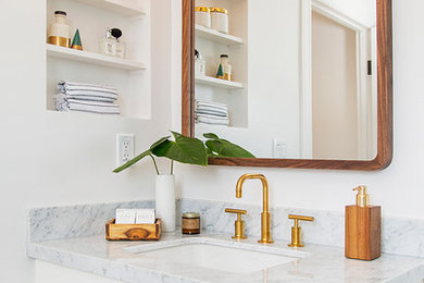 Bathroom - mid-sized 1960s bathroom idea in Los Angeles with flat-panel cabinets, white cabinets, white walls, an undermount sink, marble countertops and gray countertops