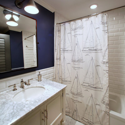 Alcove bathtub - tropical white tile and subway tile alcove bathtub idea in Tampa with an undermount sink, white cabinets, recessed-panel cabinets and gray countertops