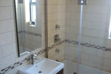 Exempel på ett klassiskt badrum, med släta luckor, skåp i mörkt trä, ett badkar i en alkov, en dusch i en alkov, en toalettstol med separat cisternkåpa, beige kakel och stenkakel