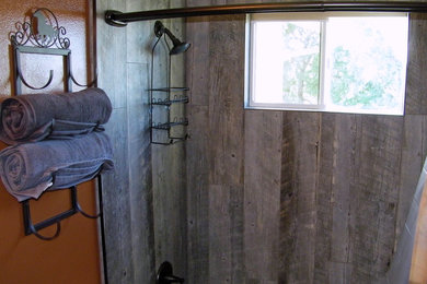 This is an example of a small rustic shower room bathroom in Sacramento with a built-in bath, a shower/bath combination, a one-piece toilet, grey tiles, porcelain tiles, orange walls and porcelain flooring.