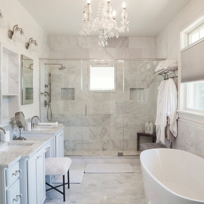 Bathroom - coastal master gray tile, white tile and marble tile marble floor and gray floor bathroom idea in New York with recessed-panel cabinets, white cabinets, gray walls, an undermount sink, marble countertops, a hinged shower door and gray countertops