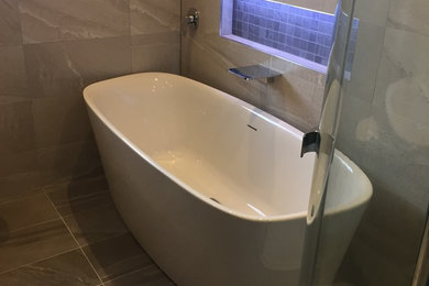 Medium sized contemporary family bathroom in Other with flat-panel cabinets, dark wood cabinets, a freestanding bath, a corner shower, a one-piece toilet, grey tiles, porcelain tiles, grey walls, porcelain flooring and a built-in sink.
