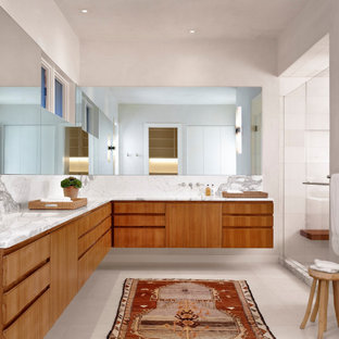 Großes Mid-Century Badezimmer En Suite mit flächenbündigen Schrankfronten, braunen Schränken, weißen Fliesen, beiger Wandfarbe, Einbauwaschbecken, Marmor-Waschbecken/Waschtisch, weißem Boden und weißer Waschtischplatte in Austin