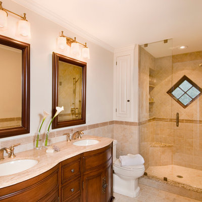 Alcove shower - traditional beige tile ceramic tile alcove shower idea in Boston with an undermount sink, furniture-like cabinets, medium tone wood cabinets, a two-piece toilet, white walls and a hinged shower door
