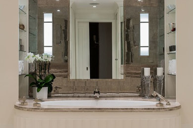 Example of a large transitional beige tile and stone tile limestone floor alcove shower design in Boston with an undermount sink, furniture-like cabinets, white cabinets, limestone countertops, an undermount tub and beige walls