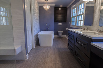 This is an example of a large contemporary ensuite bathroom in New York with flat-panel cabinets, dark wood cabinets, a freestanding bath, a built-in shower, a wall mounted toilet, white tiles, porcelain tiles, purple walls, porcelain flooring, a submerged sink, engineered stone worktops, grey floors and an open shower.