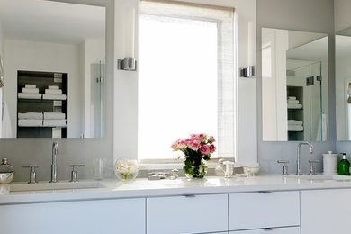 Large trendy master white tile bathroom photo in New York with flat-panel cabinets, white cabinets, white walls, an undermount sink and solid surface countertops