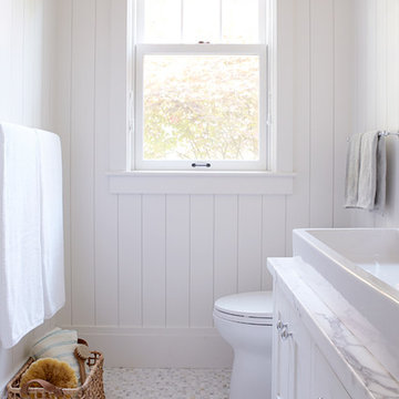 White bathroom with tile floor and lots of light