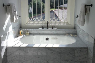 Diseño de cuarto de baño principal romántico con encimera de mármol, bañera encastrada sin remate, baldosas y/o azulejos blancos, baldosas y/o azulejos de piedra y suelo de mármol