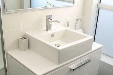 Imagen de cuarto de baño contemporáneo de tamaño medio con puertas de armario blancas, ducha esquinera, baldosas y/o azulejos blancos, baldosas y/o azulejos de cerámica y suelo de baldosas de cerámica