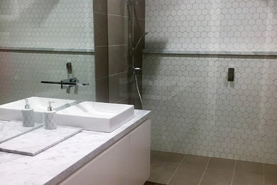 メルボルンにあるモダンスタイルのおしゃれな浴室 (オープン型シャワー、モノトーンのタイル、磁器タイル、磁器タイルの床、大理石の洗面台、オープンシャワー) の写真