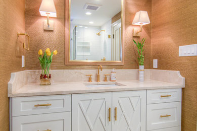 Example of a large trendy 3/4 white tile and subway tile porcelain tile and beige floor corner shower design in Philadelphia with shaker cabinets, white cabinets, a two-piece toilet, brown walls, an undermount sink, marble countertops, a hinged shower door and beige countertops