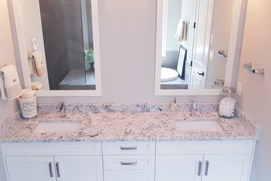 Example of a mid-sized transitional master drop-in bathtub design in Vancouver with shaker cabinets, white cabinets, an undermount sink, granite countertops, white countertops and gray walls