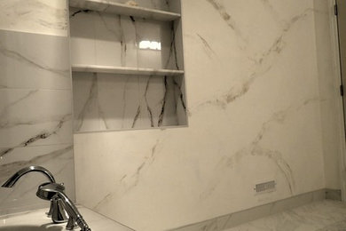 Mid-sized transitional 3/4 white tile and stone slab marble floor and white floor bathroom photo in Toronto with beaded inset cabinets, white cabinets, white walls, an integrated sink and solid surface countertops