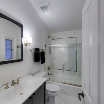 Mid-sized elegant master white tile and stone tile marble floor bathroom photo in Chicago with an integrated sink, flat-panel cabinets, black cabinets, solid surface countertops, a one-piece toilet and white walls