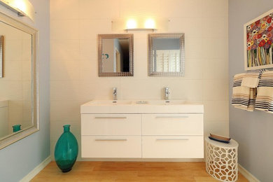 Example of a mid-sized minimalist master white tile and porcelain tile light wood floor and beige floor bathroom design in Other with flat-panel cabinets, white cabinets, gray walls, an integrated sink, quartz countertops and white countertops