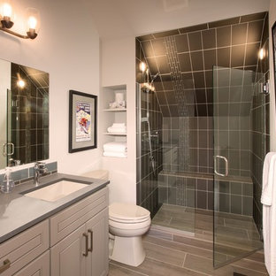 Foto di una stanza da bagno con doccia stile rurale di medie dimensioni con ante con bugna sagomata, ante grigie, doccia a filo pavimento, WC a due pezzi, piastrelle grigie, piastrelle di vetro, pareti grigie, pavimento in gres porcellanato, lavabo sottopiano, top in superficie solida, pavimento grigio e porta doccia a battente