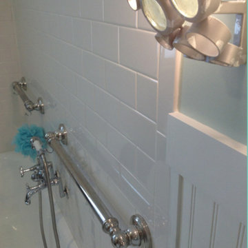 White subway tile with decorative grab bars around a vintage tub