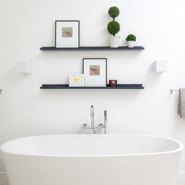 White Walled Bathroom with Standalone Tub and Floating Shelves