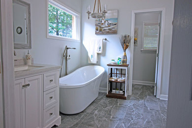 Trendy master porcelain tile porcelain tile and gray floor bathroom photo in Jackson with shaker cabinets, white cabinets, a one-piece toilet, gray walls, an undermount sink, granite countertops and a hinged shower door