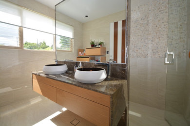 シドニーにある広いコンテンポラリースタイルのおしゃれな浴室 (家具調キャビネット、淡色木目調キャビネット、コーナー設置型シャワー、ベッセル式洗面器、御影石の洗面台、開き戸のシャワー) の写真