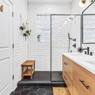 Bild på ett mellanstort funkis vit vitt en-suite badrum, med släta luckor, skåp i mellenmörkt trä, våtrum, en toalettstol med hel cisternkåpa, vit kakel, vita väggar, ett undermonterad handfat, bänkskiva i kvarts, svart golv och dusch med gångjärnsdörr