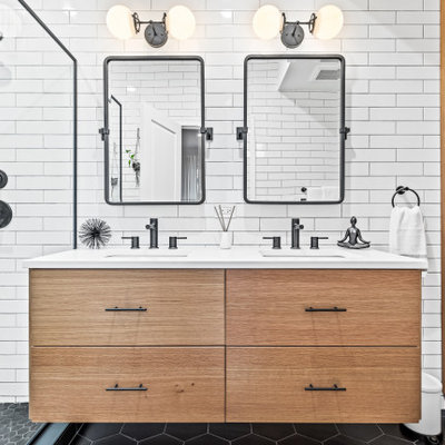 Wet room - mid-sized contemporary master white tile black floor and double-sink wet room idea in Chicago with flat-panel cabinets, medium tone wood cabinets, a one-piece toilet, white walls, an undermount sink, quartz countertops, a hinged shower door, white countertops and a built-in vanity