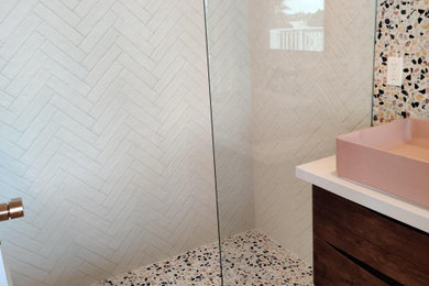Inspiration for a small contemporary master white tile and porcelain tile terrazzo floor and multicolored floor bathroom remodel in San Diego with medium tone wood cabinets, a wall-mount toilet, white walls, a vessel sink, quartz countertops and beige countertops