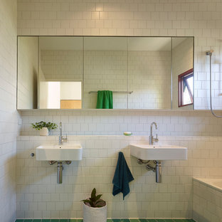 Kleines Mid-Century Kinderbad mit Einbaubadewanne, Duschbadewanne, weißen Fliesen, Keramikfliesen, weißer Wandfarbe, Keramikboden, Wandwaschbecken, gefliestem Waschtisch, grünem Boden, Duschvorhang-Duschabtrennung und weißer Waschtischplatte in Townsville