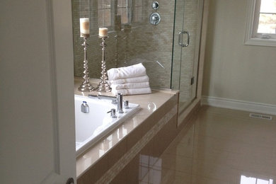Example of a mid-sized classic master beige tile and mosaic tile ceramic tile and beige floor corner shower design in Toronto with recessed-panel cabinets, beige cabinets, a hot tub, a one-piece toilet, beige walls, a drop-in sink, marble countertops, a hinged shower door and black countertops