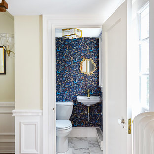 Exemple d'une petit salle d'eau chic avec un WC à poser, un mur bleu, un sol en marbre, un lavabo suspendu, un sol jaune et un plan de toilette blanc.