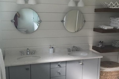Foto de cuarto de baño tradicional renovado con armarios con paneles lisos, puertas de armario grises, ducha empotrada, paredes blancas, suelo de baldosas de porcelana, lavabo bajoencimera y encimera de mármol