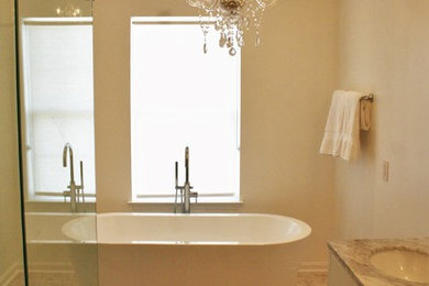 Cette image montre une salle de bain principale traditionnelle de taille moyenne avec un placard à porte shaker, des portes de placard blanches, un plan de toilette en quartz, une baignoire indépendante, une douche d'angle, un carrelage gris, des carreaux de porcelaine, un mur beige, un sol en galet, un lavabo encastré, un sol beige et une cabine de douche à porte battante.