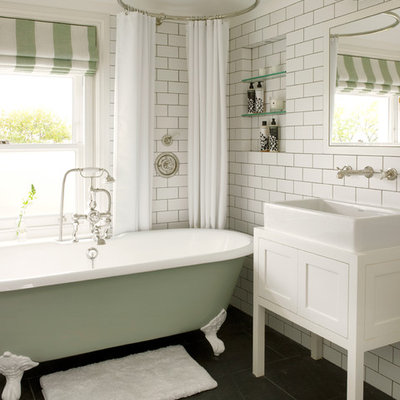 Inspiration for a small transitional kids' white tile and subway tile slate floor and gray floor bathroom remodel in London with a vessel sink, furniture-like cabinets, white cabinets, a wall-mount toilet, white walls, wood countertops and white countertops