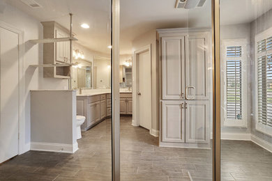 Walk-in shower - mid-sized traditional master white tile and porcelain tile walk-in shower idea in New Orleans with raised-panel cabinets, gray cabinets, quartz countertops, a hinged shower door and gray countertops