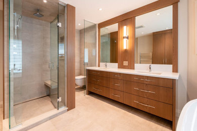 Inspiration for a large 1950s master beige tile and porcelain tile porcelain tile and beige floor bathroom remodel in Ottawa with flat-panel cabinets, medium tone wood cabinets, a wall-mount toilet, beige walls, an undermount sink, quartz countertops, a hinged shower door and white countertops